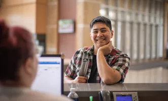 Student interacting with front desk assistant