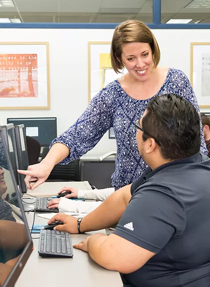 two people reviewing information on a computer monitor