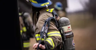 Firefighter student putting on gear