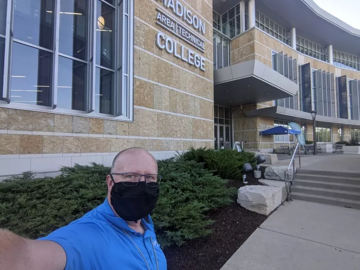 Instructor Peter Dettmer stands outside Truax Campus wearing a mask. 