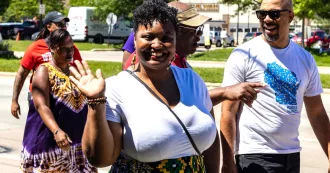 A woman waving in the Madison Juneteenth Parade in 2022.