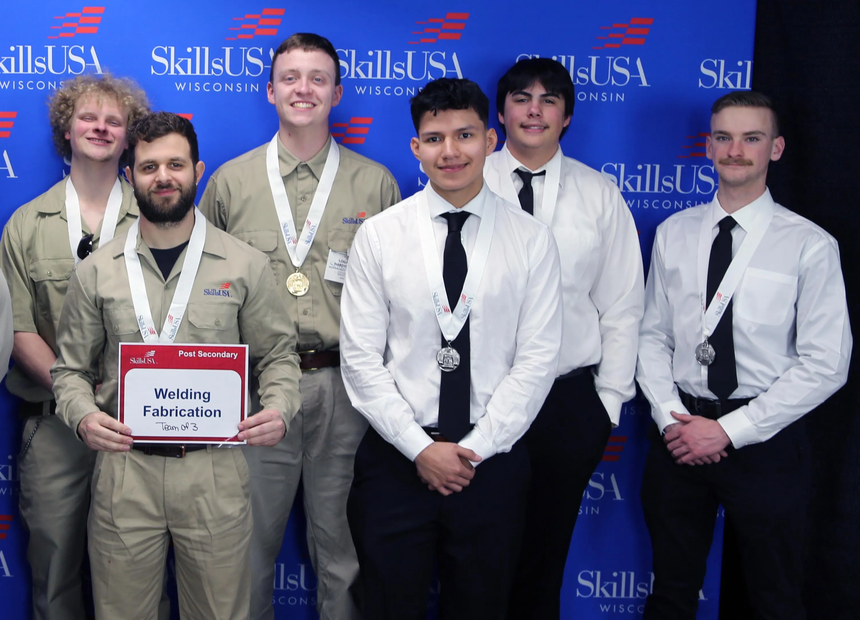 Students in the SkillsUSA team (Welding Fabrication) pose with their gold and silver medals around their necks.